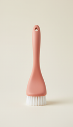 A sleek bathroom scrubbing brush is precisely centered on a light, shadowless lighting ensures the product remains the...